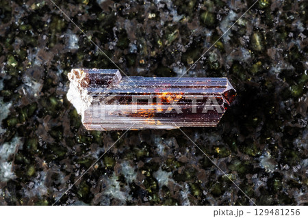 sample of rough rutile crystal on black granite 129481256