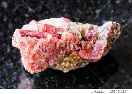 sample of rough rhodonite rock on black sample of rough rhodonite rock on black 129481384