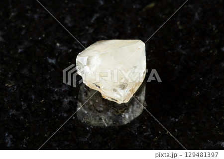 sample of rough topaz crystal on black granite 129481397