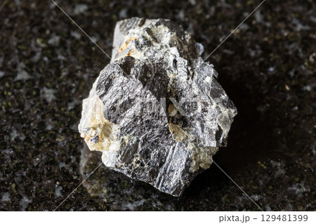 sample of rough wolframite rock on black granite 129481399