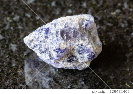 sample of rough cordierite rock on black granite 129481403
