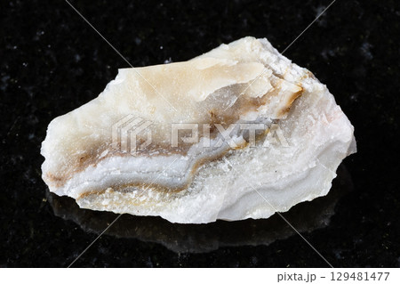 sample of raw shaitan perelivte mineral on black 129481477