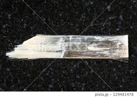 sample of rough nemalite mineral on black granite 129481478