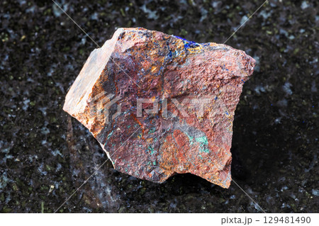 sample of raw zarinite rock on black granite 129481490