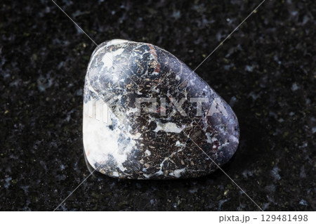 sample of polished trachybasalt rock on black 129481498