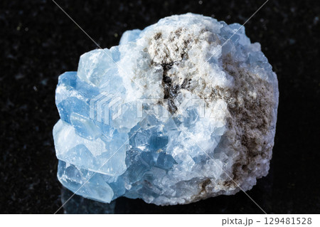 sample of raw celestite mineral on black granite 129481528