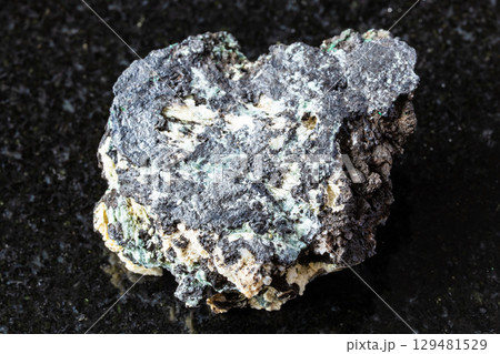 sample of raw tenorite rock on black granite 129481529