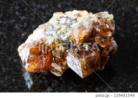 sample of raw hessonite grossular rock on black sample of raw hessonite grossular rock on black 129481549