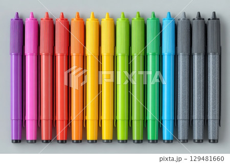 A vibrant collection of markers displayed in a straight line features various colors including purple, red, orange, yellow, green, and black, showcasing an organized, artistic arrangement. 129481660