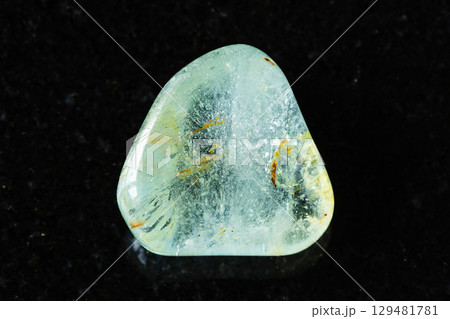 sample of tumbled blue topaz mineral on black 129481781