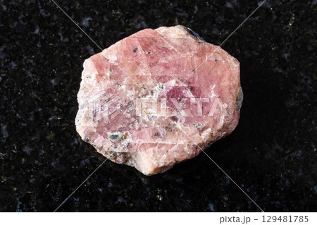 sample of rough pink ruby mineral on black granite sample of rough pink ruby mineral on black granite 129481785