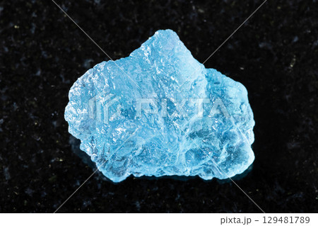sample of rough aquamarine mineral on black 129481789