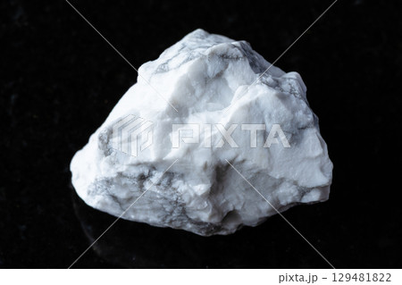 sample of raw howlite mineral on black granite sample of raw howlite mineral on black granite 129481822