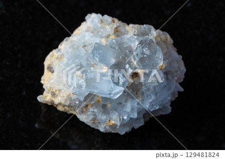 sample of rough celestine rock on black granite 129481824