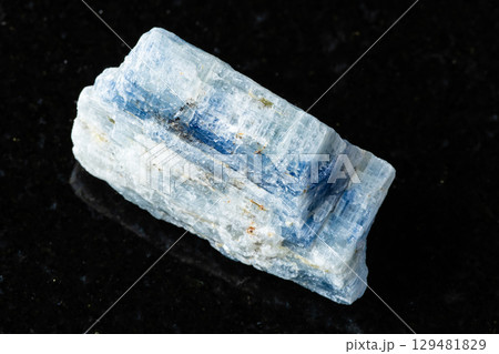 sample of uncut kyanite rock on black granite 129481829