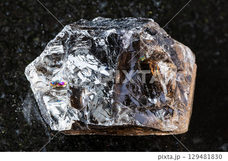 sample of raw smoky quartz rock on black granite 129481830