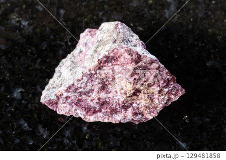 sample of raw piemontite rock on black granite 129481858