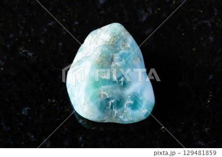 sample of rough larimar mineral on black granite 129481859