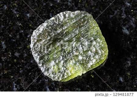 sample of rough moldavite tektite glass on black 129481877