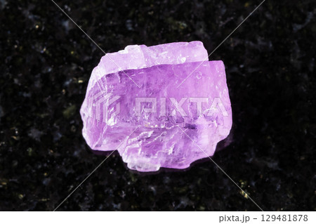 sample of rough kunzite crystal on black granite sample of rough kunzite crystal on black granite 129481878