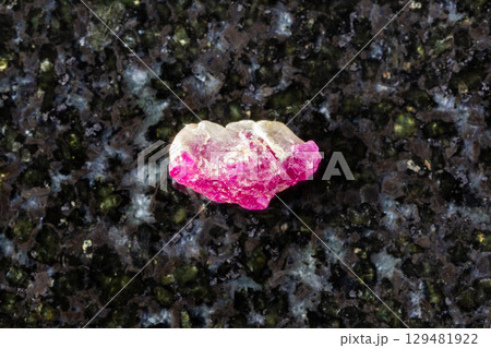 sample of rough pink ruby mineral on black granite sample of rough pink ruby mineral on black granite 129481922