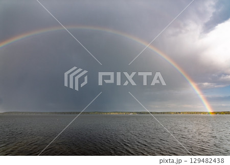 Rainbow over Blue lake with cloudy sky Rainbow over Blue lake with cloudy sky 129482438