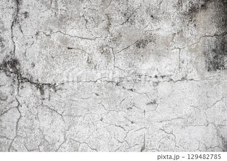 Close up of old stucco cracks on the wall, Old cracked paint on the concrete wall, Weathered paint cracks on plaster. Cracked wall background. 129482785