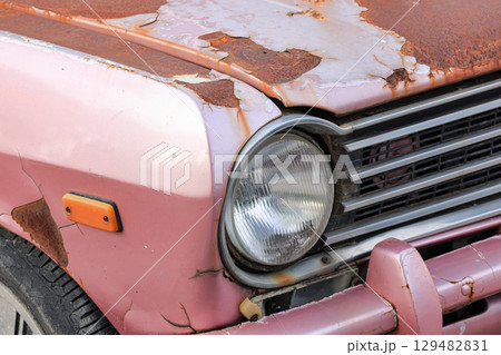 The car headlights of abandoned old rusty car on the side of the road. The car headlights of abandoned old rusty car on the side of the road. 129482831
