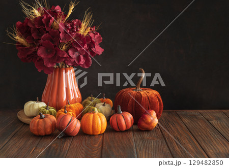 Autumnal composition of decorative mini pumpkins on a wooden surface. 129482850