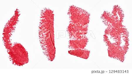 Close-up of four strokes made with red lipstick. The strokes have uneven texture and jagged edges 129483143