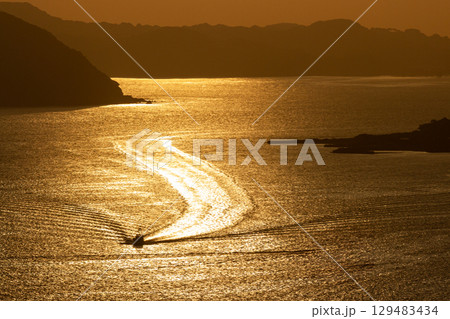 黄金色に輝く夕暮れの海と船 129483434