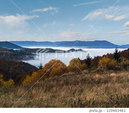Foggy early morning autumn mountains scene. Peaceful picturesque traveling, seasonal, nature and countryside beauty concept scene. Carpathian Mountains, Ukraine. Foggy early morning autumn mountains scene. Peaceful picturesque traveling, seasonal, nature and countryside beauty concept scene. Carpathian Mountains, Ukraine. 129483461