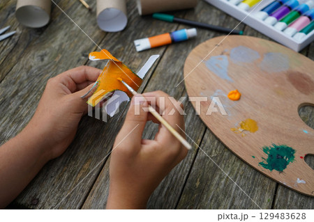 DIY and kid's creativity. Step by step instruction: how to make tiger from toilet roll tube. Step four, cover the entire roll with orange paint. DIY and kid's creativity. Step by step instruction: how to make tiger from toilet roll tube. Step four, cover the entire roll with orange paint. 129483628