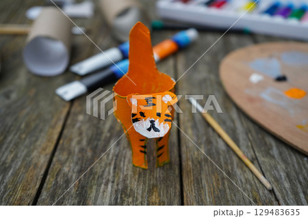 DIY and kid's creativity. Step by step instruction: how to make tiger from toilet roll tube. Step six: draw tiger stripes with black paint. 129483635