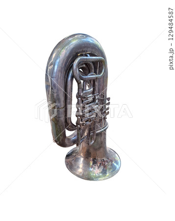 A tuba sits alone, showcasing its brass curves and valves. The shiny surface reflects light, highlighting the craftsmanship and details of this wind instrument used in various music genres. 129484587