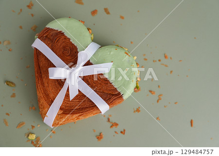 Present gift ribbon holiday Valentine's Birthday love symbol Delightful and vibrant heartshaped pastry croissant treat, beautifully topped with colorful frosting nut galore. Mock up template copy 129484757