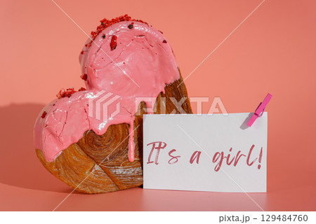 Gender party baby shower IT'S A GIRL wishes saying caption on greeting card Delightful heartshaped pastry croissant treat, beautifully topped with colorful frosting galore. Copy space. Food Gender party baby shower IT'S A GIRL wishes saying caption on greeting card Delightful heartshaped pastry croissant treat, beautifully topped with colorful frosting galore. Copy space. Food 129484760