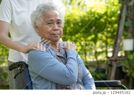 caregiver help and care Asian senior woman patient sitting on wheelchair at nursing hospital ward, healthy strong medical. 129485162