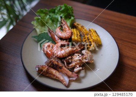 Grilled seafood corn Mixed corn and seafood barbecue. Grilled corn and chicken on the barbecue. Grilled prawns sizzle on the barbecue when the prawn is flipped. 129485170