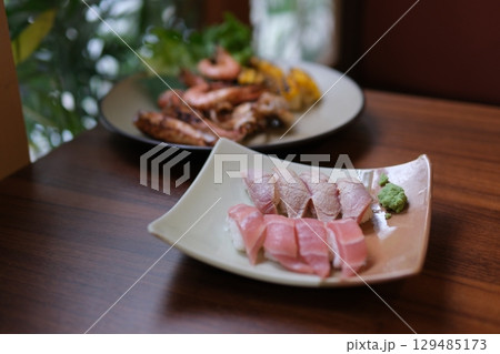 Sushi dish tuna Sashimi Nigiri Platter, japanese sushi restaurant, Fresh Tuna and Salmon Slices in modern cafe, traditional food, raw red fish dish, omega 3. 129485173