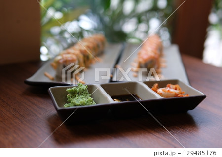 Chopsticks Japan Sushi In Japanese Restaurant.Traditional Sushi Maki Rolls Sushi Salmon Philadelphia Cheese Avocado, Cucumber, Rice And Nori. Japanese Food Sushi Roll Uramaki, Nigiri And Hosomaki Chopsticks Japan Sushi In Japanese Restaurant.Traditional Sushi Maki Rolls Sushi Salmon Philadelphia Cheese Avocado, Cucumber, Rice And Nori. Japanese Food Sushi Roll Uramaki, Nigiri And Hosomaki 129485176