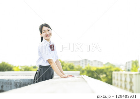 学校の屋上から景色を見る女子高生　カメラ目線 129485931