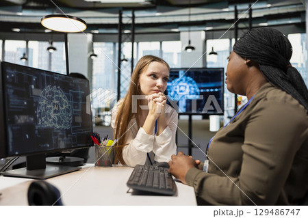 Young employee at desk pleading with AI tech startup manager for time off from work. Worker seeking help from artificial intelligence company team leader in professional workspace Young employee at desk pleading with AI tech startup manager for time off from work. Worker seeking help from artificial intelligence company team leader in professional workspace 129486747