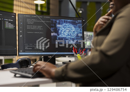 Close up of IT specialist in tech startup using artificial intelligence on PC to optimize performance and forecast issues. Technician in office training deep learning models using computer 129486754