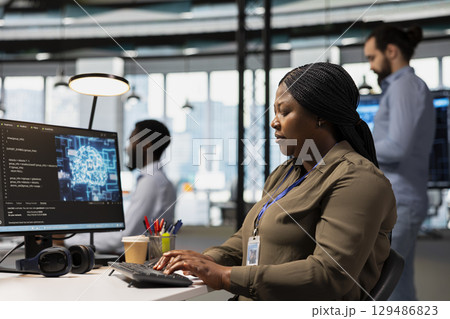 Software engineer using AI automation in tech workspace, building digital solutions. African american IT specialist working on PC to identify and fix bugs using artificial intelligence tools 129486823