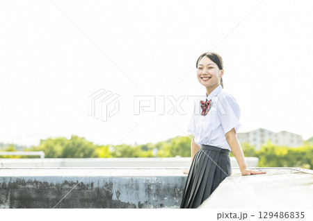 学校の屋上から景色を見る女子高生 カメラ目線 学校の屋上から景色を見る女子高生 カメラ目線 129486835