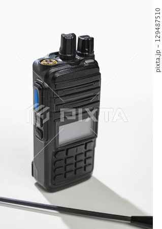 Closeup view of a black walkie talkie radio communication device isolated over a white background Closeup view of a black walkie talkie radio communication device isolated over a white background 129487510