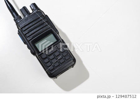Closeup view of a black walkie talkie radio communication device isolated over a white background Closeup view of a black walkie talkie radio communication device isolated over a white background 129487512