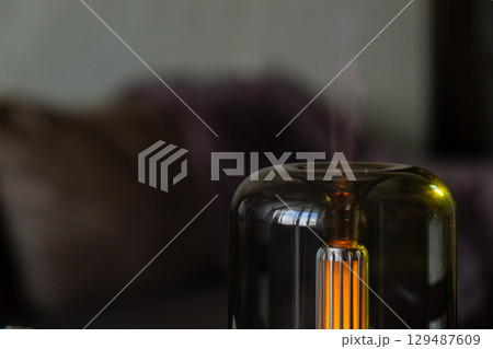 Close up of home perfume scent air humidifier with light. Aromatherapy holistic health practices concept. Stress relief activities preparing for meditation. Simple pleasures healing 129487609