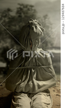 Pocong on the field at night. A traditional ghost from Indonesia that takes the form of a human wrapped in a shroud or winding sheet. Concept of Halloween Pocong on the field at night. A traditional ghost from Indonesia that takes the form of a human wrapped in a shroud or winding sheet. Concept of Halloween 129487684